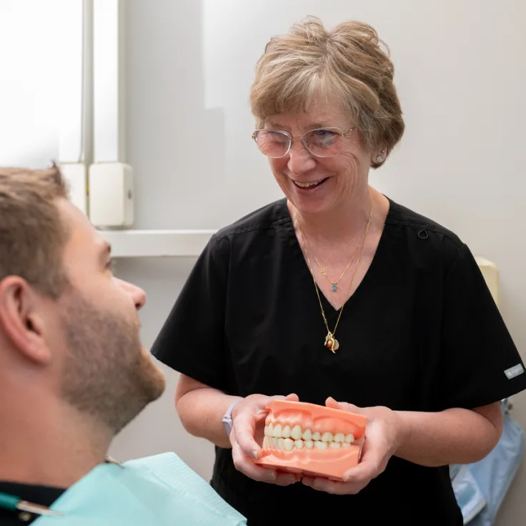 Lumon Dental team member explaining treatment with a dental model